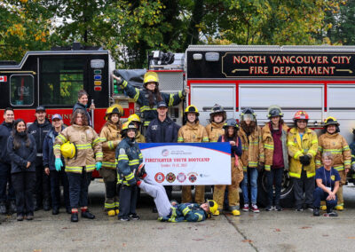 All the students, FNESS team, and firefighters standing in front of the fire engine.