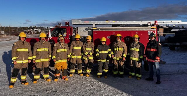 Ulkatcho firefighters standing outside a fire engine.